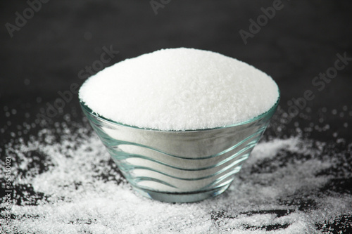 A glass bowl with white sugar