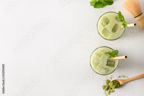 Two glasses of iced green matcha tea on white background. Space for text. View from above.