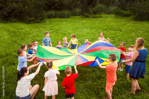Outdoor games with colorful parachute. Summer camp