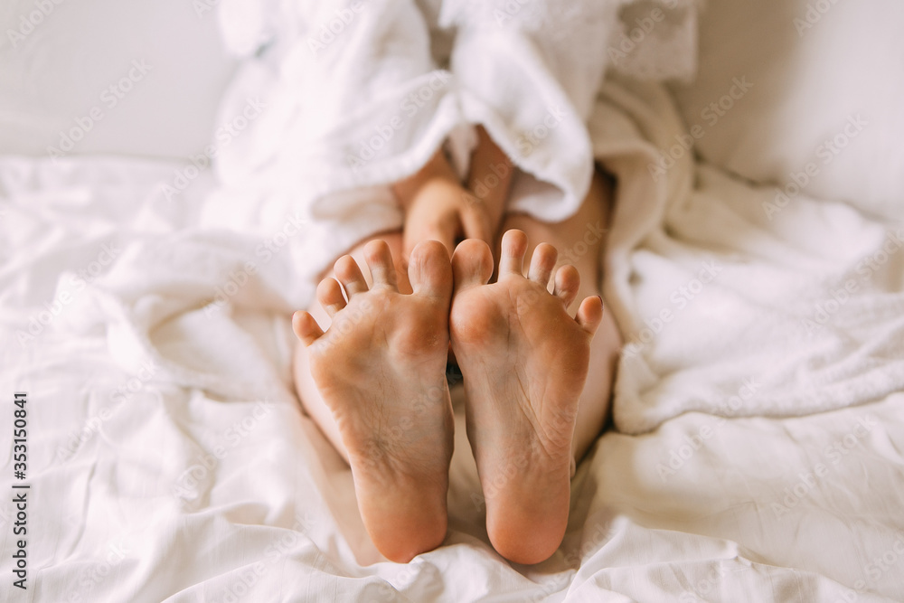 girl sitting on the bed and shows her feet girl sitting on the bed and shows her feet