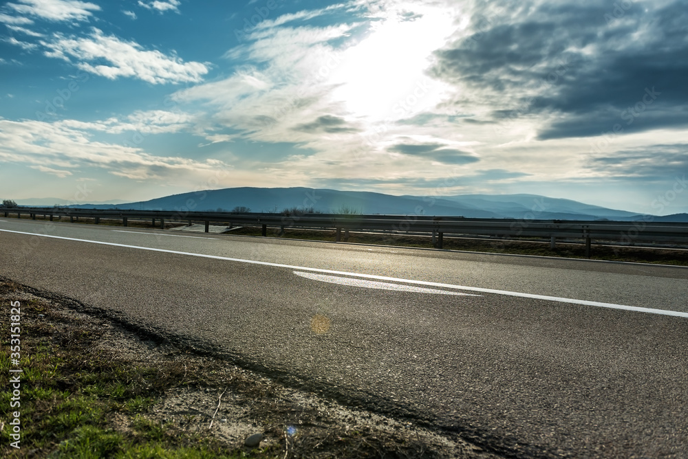 Beautiful silent freeway road. Asphalt highway background. Landscape with beautiful sunset
