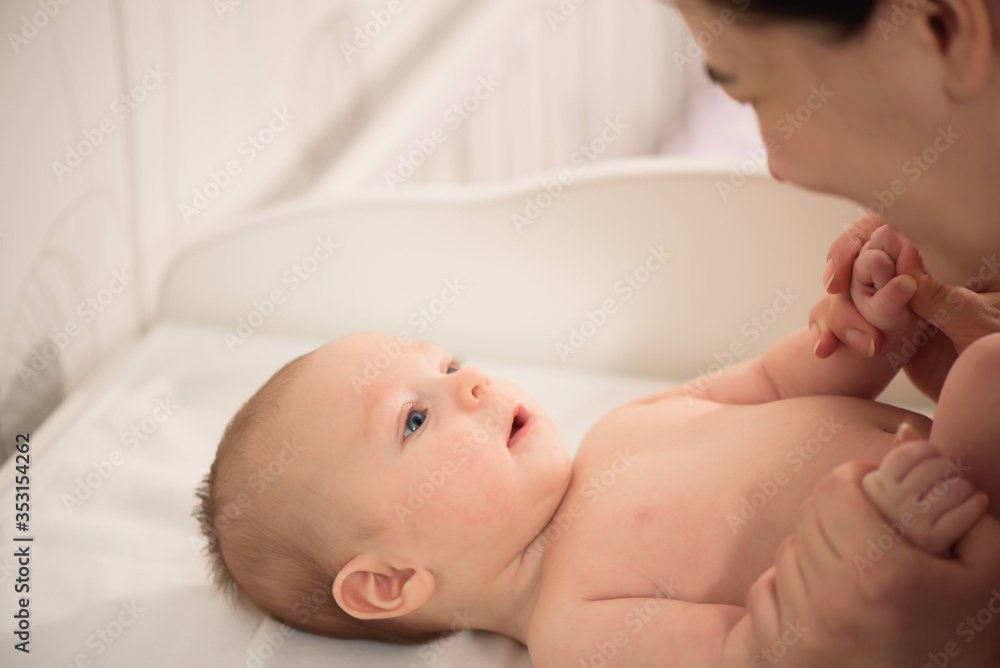 Mom nursing baby. Woman and new born boy relax in a white bedroom. Family at home. Mom nursing baby. Woman and new born boy relax in a white bedroom. Family at home.