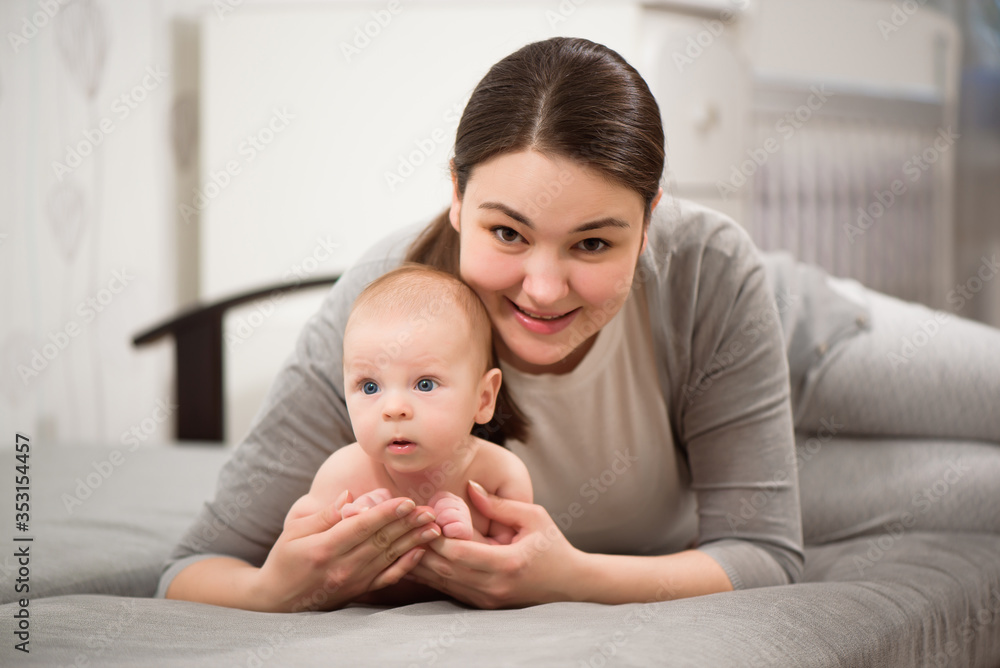 Happy family. Mother playing with her baby in the bedroom. Happy family. Mother playing with her baby in the bedroom.