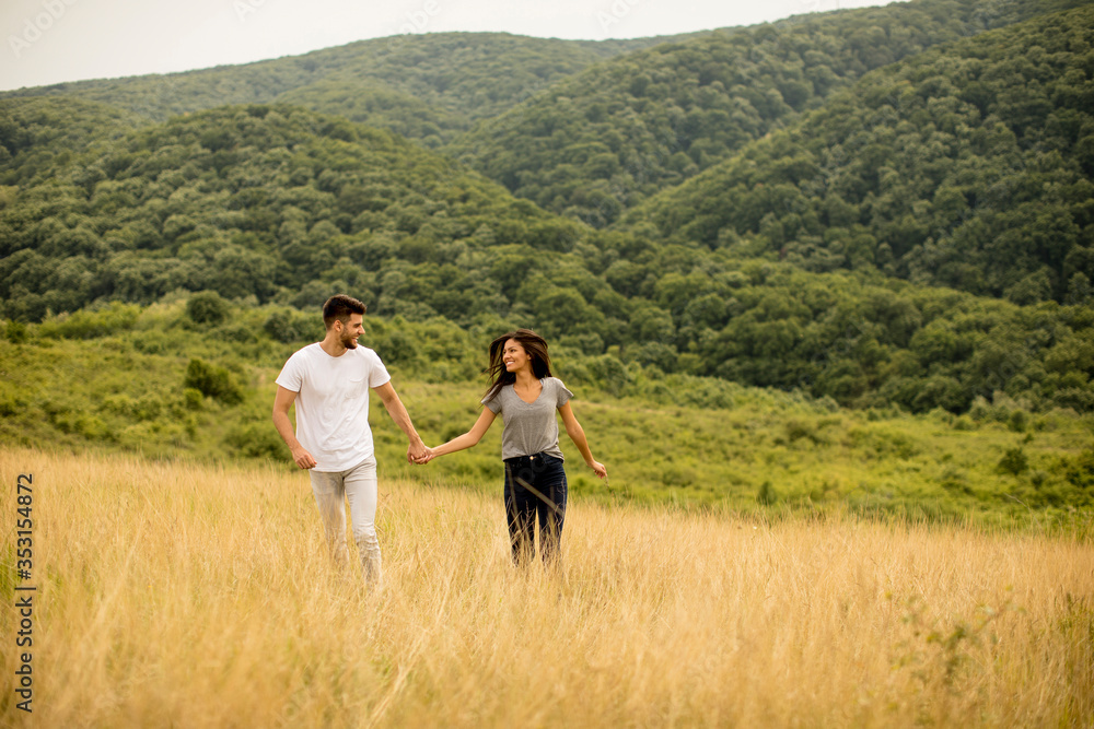 Young couple in love walking through grass field
