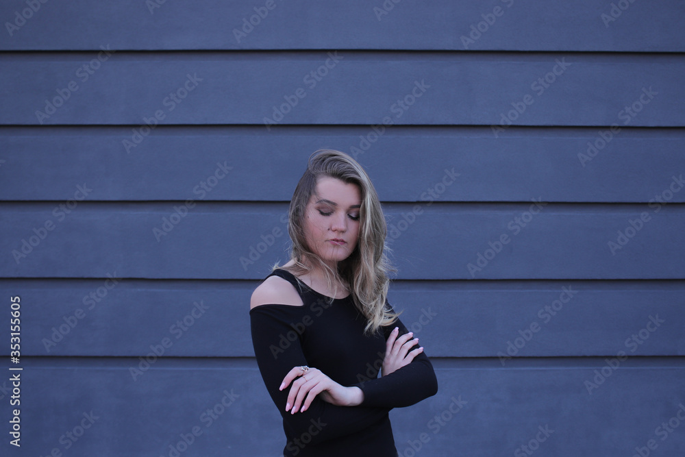 urban portrait of a pensive flirty beautiful young woman in black blouse on a background of gray wall in strips urban portrait of a pensive flirty beautiful young woman in black blouse on a background of gray wall in strips