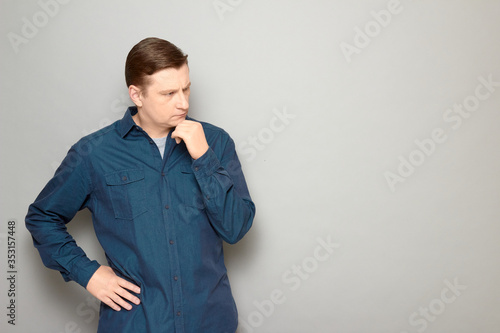 Portrait of man being deep in thoughts and touching chin with hand