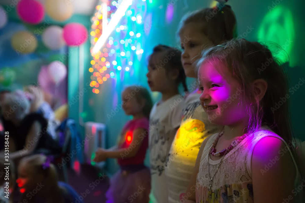 Celebrating the birthday of children.Children at a party in colored rays