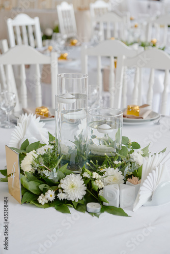 Lush floral arrangement of white chrysanthemum flowers and candles on table, copy space. Luxury wedding decorations