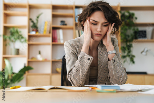 Photos Beautiful young businesswoman sitting at the office desk