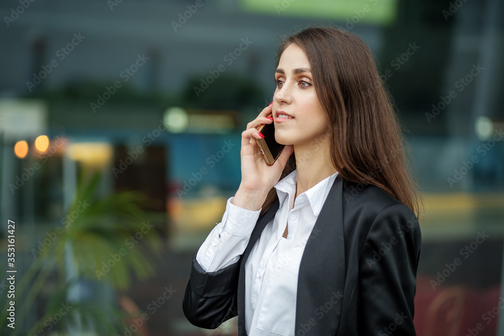 Successful business woman talking on a smartphone. The concept of the Internet, technology, business, communication and lifestyle Successful business woman talking on a smartphone. The concept of the Internet, technology, business, communication and lifestyle