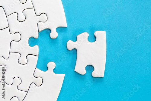 Fotografía White jigsaw puzzle pieces on a blue background