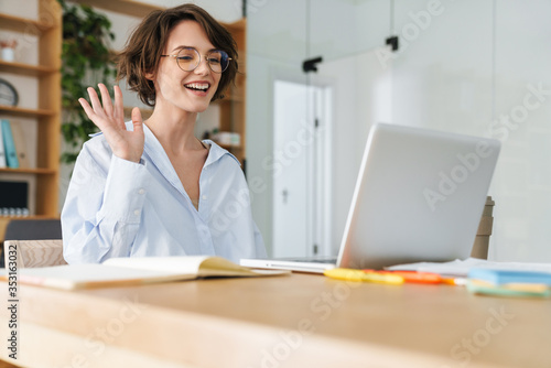 Beautiful young businesswoman sitting at the office desk © Drobot Dean