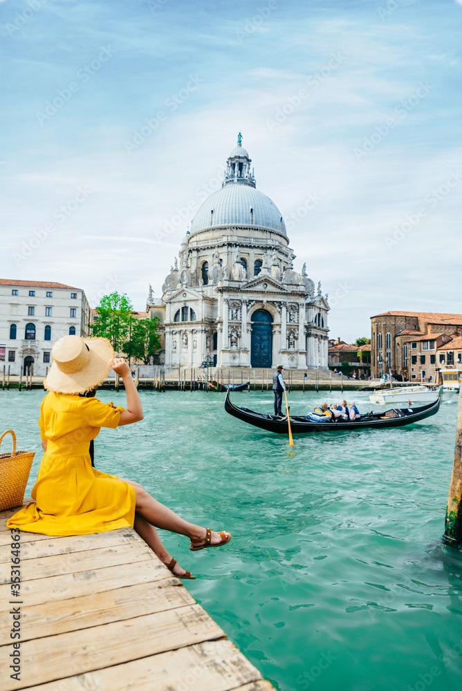 woman in yellow sundress sitting on pier with view of grand canal
