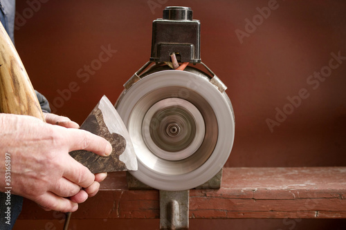 фотографія Sharpening an ax on an old emery machine