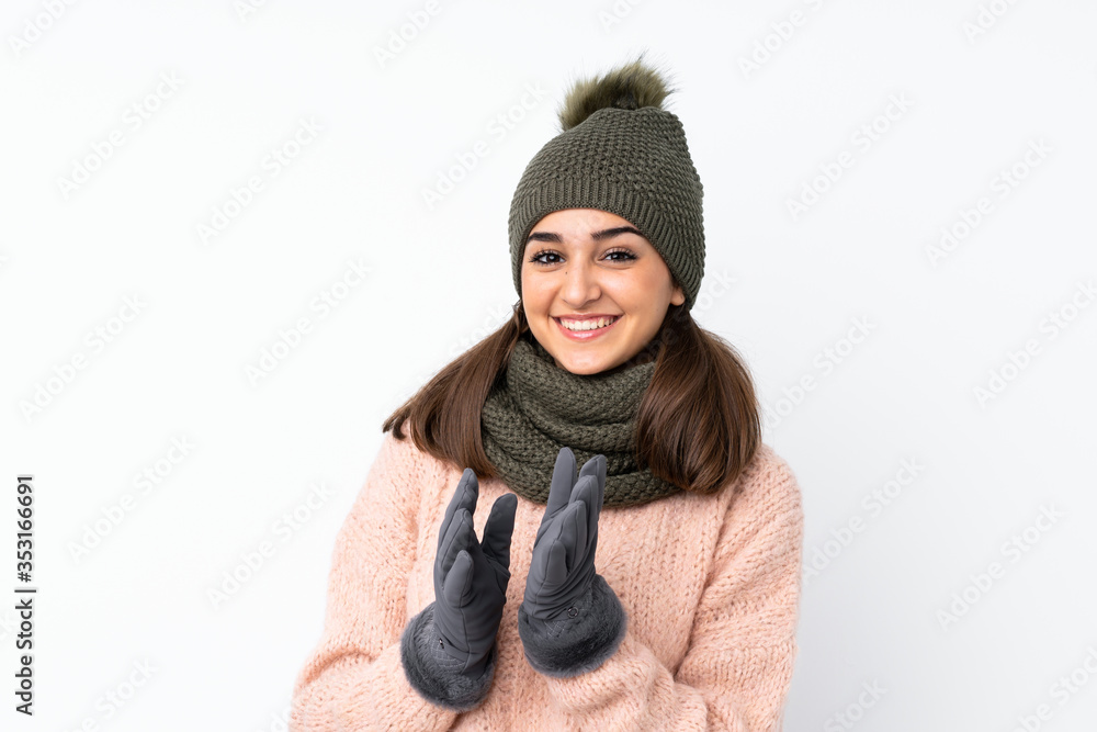 Young girl with winter hat over isolated white background applauding Young girl with winter hat over isolated white background applauding