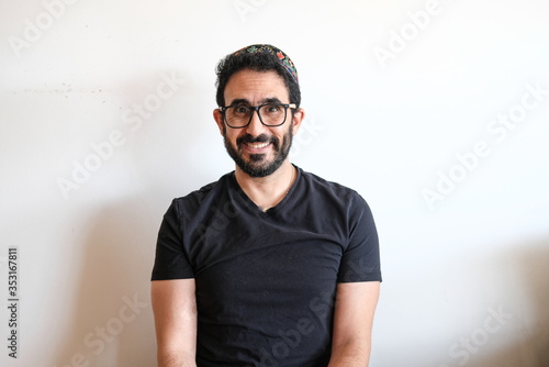 Jewish bearded man sitting. The man is wearing a simbolic and big  kippah on his head