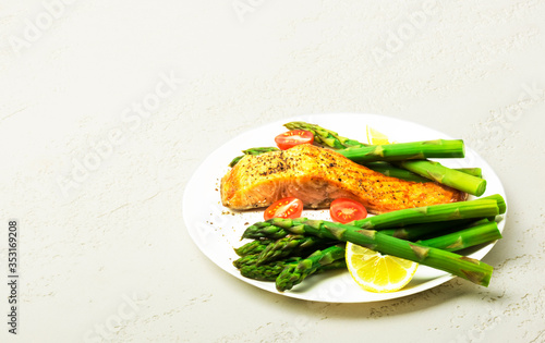 Baked salmon garnished with asparagus and tomatoes 