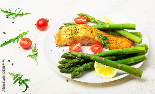 Baked salmon garnished with asparagus and tomatoes with herbs	