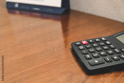 Close-up of black Calculator on wooden table