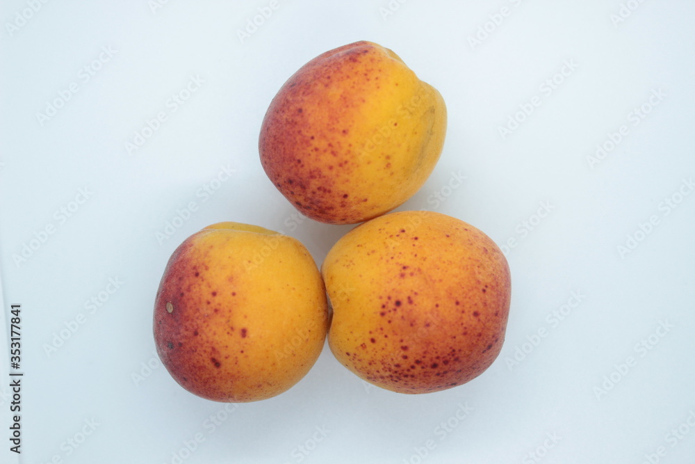 Ripe beautiful apricots are located on a white background Ripe beautiful apricots are located on a white background