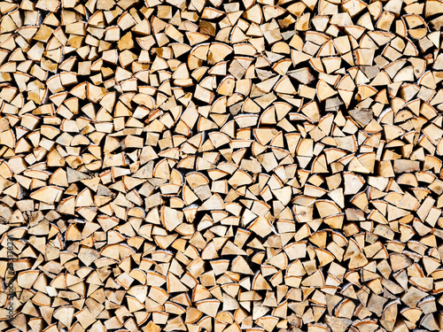 Woodpile with a lot of birch and spruce logs. Chopped a lot of firewood neatly stacked in a pile, background, texture. Harvesting wood for the winter for kindling the stove or fireplace photo