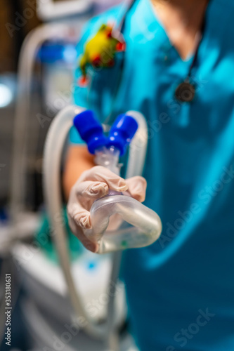Oxygen mask. Anesthetist holding oxygen mask above patient. Intensive care unit