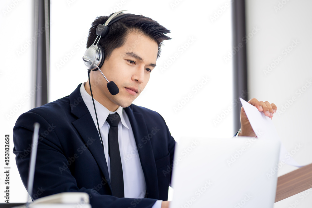 Handsome young male at a computer and phone in a call centre operator Handsome young male at a computer and phone in a call centre operator
