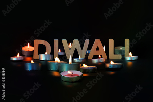 Diwali card, illuminated candles, Diwali text on dark background