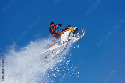 Snowmobile Jump. Extreme Snowmobile Ride   Racing. a bright suit and a snow motorcycle. Winter Recreation. high resolution and photo quality