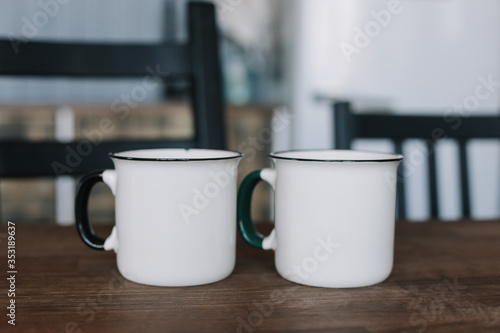 Two coffee cups on wooden table in the kitchen 