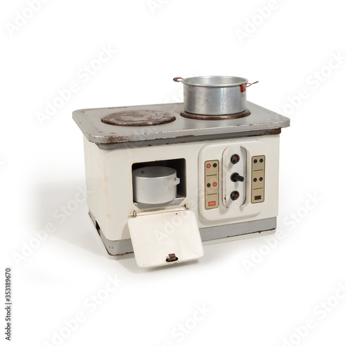 Nostalgic metal children’s toy fireside with open oven door and two aluminum pans on the hot plate, 
isolated on white background with natural abject shadow. 
