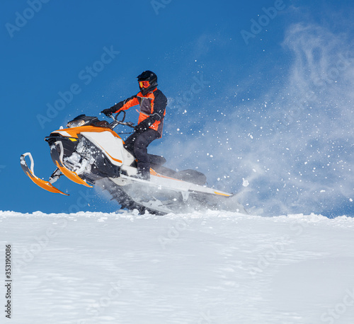 The sportsman on a snowmobile. Recreation concept on nature in winter holidays. a bright suit and a snow motorcycle. Winter sports. high resolution and photo quality