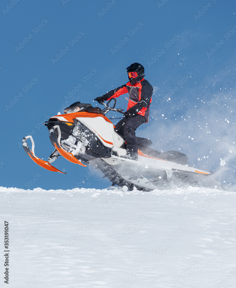 Snowmobile Jump. Extreme Snowmobile Ride & Racing. a bright suit and a snow motorcycle. Winter Recreation. high resolution and photo quality Snowmobile Jump. Extreme Snowmobile Ride & Racing. a bright suit and a snow motorcycle. Winter Recreation. high resolution and photo quality