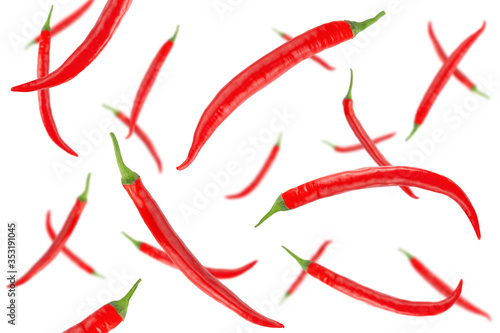 Falling red hot chilli peppers isolated on a white background with clipping path. Flying vegetables. Top view.