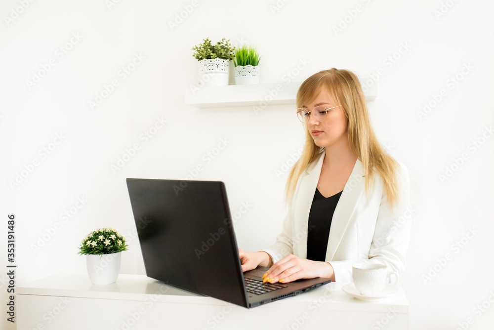 Remote work.Entrepreneur woman wearing white jacket working with a laptop sitting on a couch at home.Online consultation of a tax lawyer, accountant in the office Remote work.Entrepreneur woman wearing white jacket working with a laptop sitting on a couch at home.Online consultation of a tax lawyer, accountant in the office