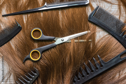 A female long hair, scissors and hair brushes on the barber table background.