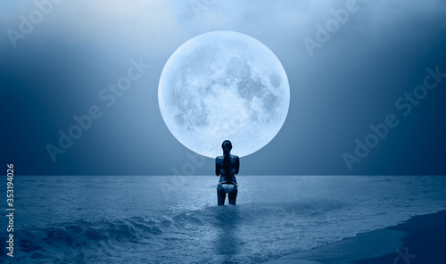 Night sky with moon in the clouds on the foreground power sea wave - Happy slim girl in white bikini  on the seashore in Alanya "Elements of this image furnished by NASA