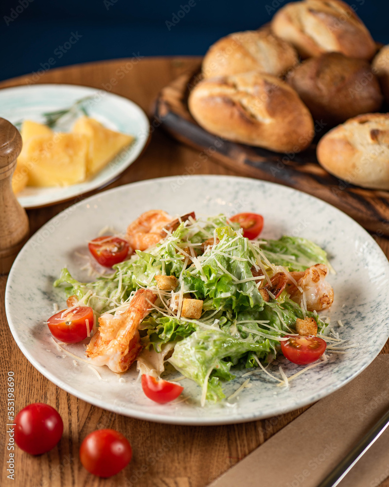 Caesar salad with prawns on a wooden table. Caesar salad with prawns on a wooden table.
