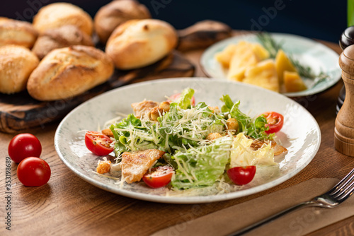 Caesar salad with chicken on a wooden table. 