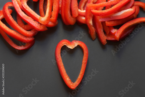 chopped slices of bell pepper, heart of red slices on a dark background
