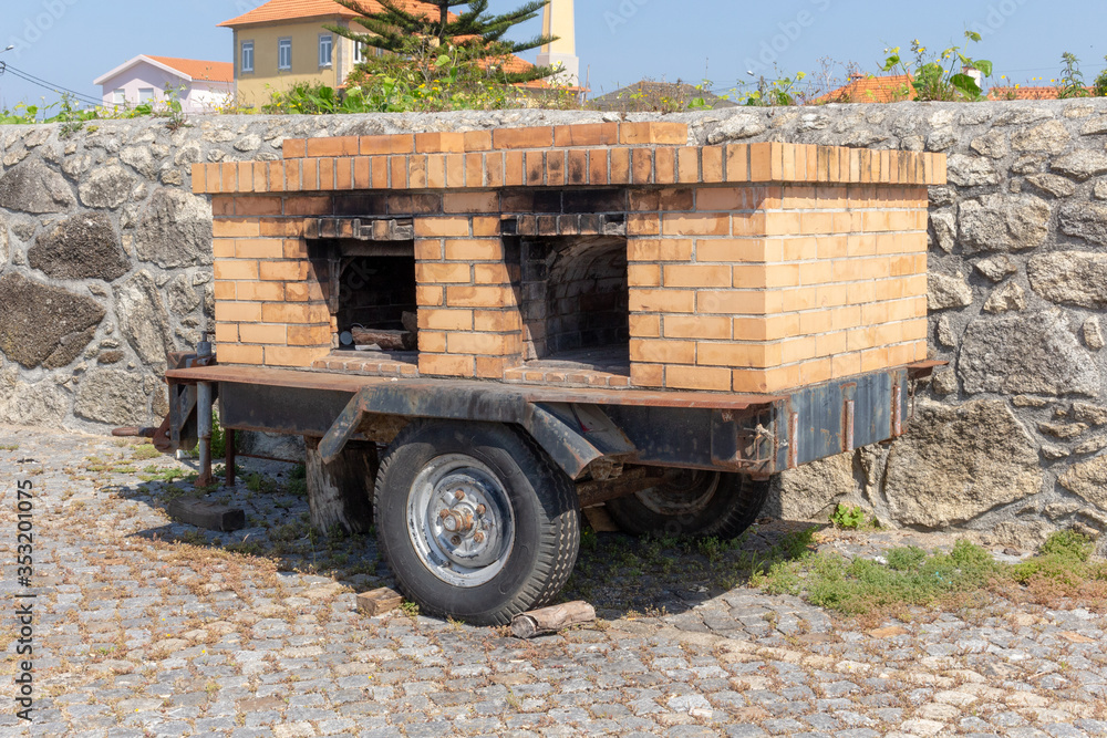 Mobile wood-fired oven trailer near the Parochial Church of Saint Bartholomew of the Sea in the parish of Mar, municipality of Esposende, North of Portugal.
