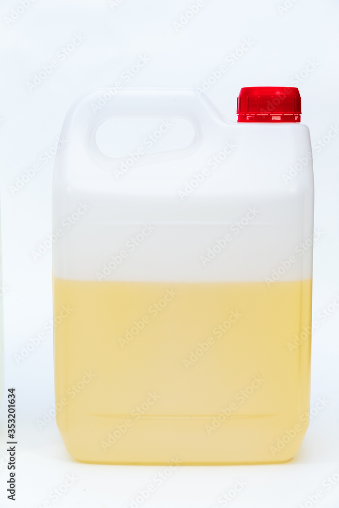 Plastic canister with yellow liquid on white background.