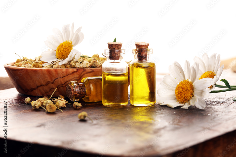 Chamomile Composition with essential oil and chamomile flowers on wooden rustic table Chamomile Composition with essential oil and chamomile flowers on wooden rustic table
