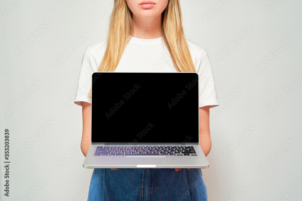 Pretty woman in a white t-shirt and jeans holds a laptop. White background. Layout for a laptop. Black screen Pretty woman in a white t-shirt and jeans holds a laptop. White background. Layout for a laptop. Black screen