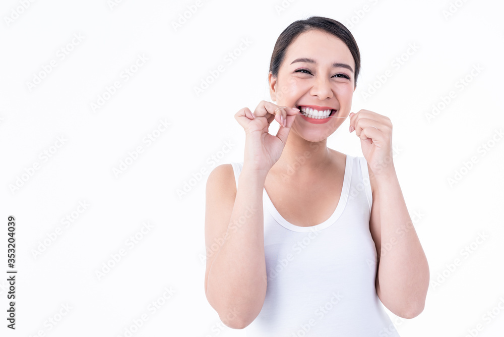 Portrait images of Asian young pretty woman, smiling, beautiful white and clean teeth, are using dental floss Clean teeth after eating For good dental health On white background to health care concept Portrait images of Asian young pretty woman, smiling, beautiful white and clean teeth, are using dental floss Clean teeth after eating For good dental health On white background to health care concept