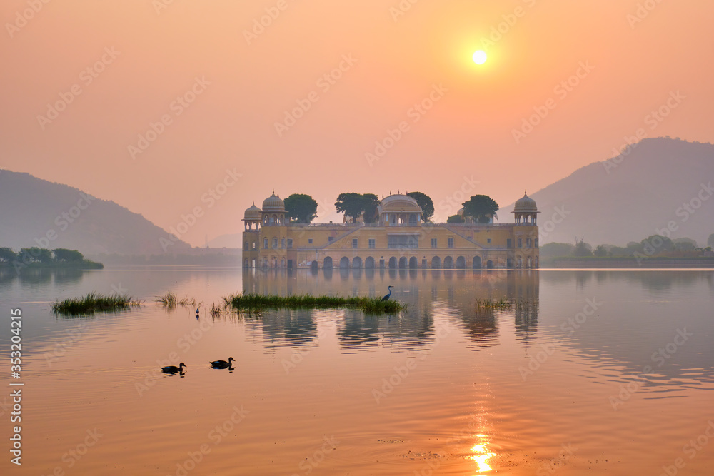 Obraz premium Tranquil morning at famous indian tourist landmark Jal Mahal (Water Palace) at sunrise in Jaipur. Ducks and birds around enjoy the serene morning. Jaipur, Rajasthan, India