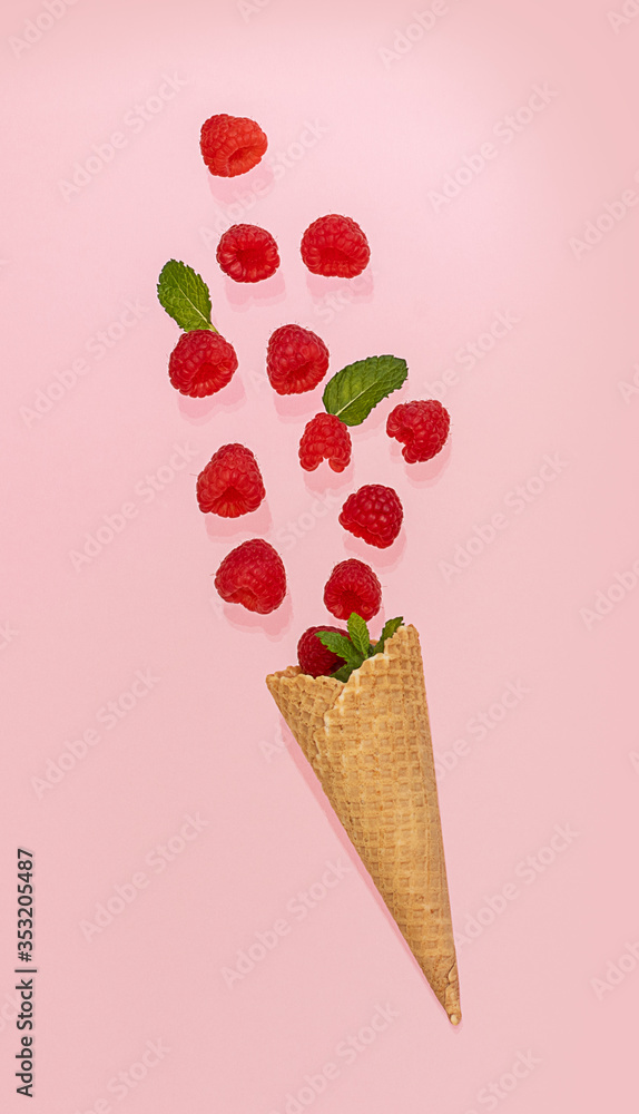 Waffle cone with fallen raspberry on the pink. Summer concept. Waffle cone with fallen raspberry on the pink. Summer concept.