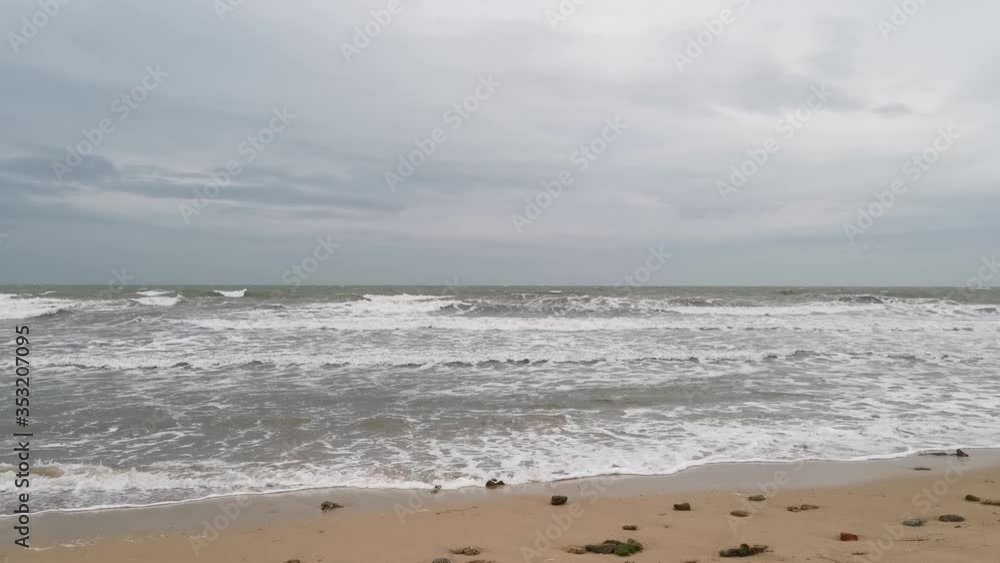 A stormy sea and a sandy beach. Beautiful grey sky and a sandy beach where the wave rolls. Swimming is prohibited. A stormy sea and a sandy beach. Beautiful grey sky and a sandy beach where the wave rolls. Swimming is prohibited.