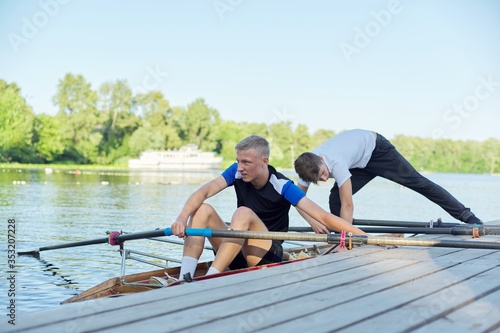 Team of two teenage boys kayaking on river