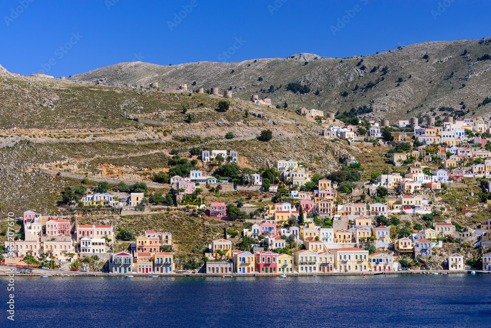 Sightseeing of Greece. The picturesque coastline of Symi island with beautiful old houses, Symi island, Dodecanese, Greece